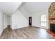 Bright living room featuring new floors, a stone fireplace, and access to the front entrance and staircase at 10432 Camelback Cir, Charlotte, NC 28226