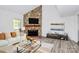 Bright living room showcasing a stone fireplace, modern furnishings, and elegant decor at 10432 Camelback Cir, Charlotte, NC 28226