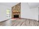 Bright living room with new floors and a charming stone fireplace, adjacent to a sunny window at 10432 Camelback Cir, Charlotte, NC 28226