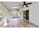 Bright sun room with ceiling fans, white ceiling and walls, and wood-look flooring at 10432 Camelback Cir, Charlotte, NC 28226
