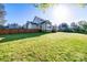 Large grassy backyard featuring a wood fence, deck, and wooded property line at 1079 Sage Pine Cir, Clover, SC 29710