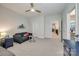 Neutral-toned bedroom featuring a cozy sofa, ceiling fan, and a glimpse into the hallway at 1079 Sage Pine Cir, Clover, SC 29710