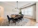 This formal dining room offers a rustic table, statement lighting, and large window at 1079 Sage Pine Cir, Clover, SC 29710