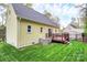 Lovely backyard shows a deck perfect for relaxing, along with green lawn and yellow siding at 110 Shamrock Ne St, Concord, NC 28025
