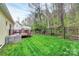 A well-manicured backyard with a deck, lush lawn, and a secure black fence at 110 Shamrock Ne St, Concord, NC 28025