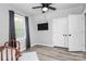 Light-filled bedroom features a ceiling fan, tv, closet, and new luxury vinyl plank flooring at 110 Shamrock Ne St, Concord, NC 28025