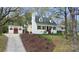 Charming yellow home with black shutters, a lush lawn and an accessory building at 110 Shamrock Ne St, Concord, NC 28025