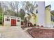 Side view of the home and shed shows their relationship on the lot and landscaping at 110 Shamrock Ne St, Concord, NC 28025