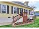 Charming yellow home with black shutters, front yard landscaping, and a inviting front porch at 110 Shamrock Ne St, Concord, NC 28025