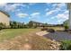 Large backyard featuring a stone fire pit, manicured lawn, and lovely neighborhood views at 11234 Smokethorn Nw Dr, Concord, NC 28027