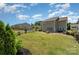 Spacious backyard with a well-maintained lawn, privacy fence, and inviting stone fire pit area at 11234 Smokethorn Nw Dr, Concord, NC 28027
