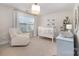 Light filled Bedroom features a white crib, comfortable chair, and large window at 11234 Smokethorn Nw Dr, Concord, NC 28027