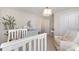 Light filled Bedroom features a white crib, comfortable chair, and changing table at 11234 Smokethorn Nw Dr, Concord, NC 28027