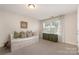 Cozy bedroom features a bed with storage drawers and a window with floral curtains at 11234 Smokethorn Nw Dr, Concord, NC 28027