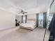 Bright bedroom featuring a tray ceiling, fan, and neutral-toned carpeting at 11234 Smokethorn Nw Dr, Concord, NC 28027