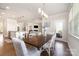 Open-concept dining room with a view of the kitchen and living room, with stylish pendant lighting at 11234 Smokethorn Nw Dr, Concord, NC 28027
