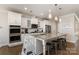 Modern kitchen featuring white cabinets, stainless steel appliances, and a large granite island with bar stool seating at 11234 Smokethorn Nw Dr, Concord, NC 28027