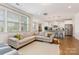Bright living room with large windows, a comfortable sectional sofa, and an open view to the kitchen at 11234 Smokethorn Nw Dr, Concord, NC 28027