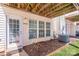 Cozy back porch featuring an exposed wood frame ceiling and a door and windows with white trim at 12036 Duke Lancaster Dr, Charlotte, NC 28277