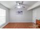 A well-lit bedroom with a ceiling fan, hardwood floors, and a modern wall decoration at 12036 Duke Lancaster Dr, Charlotte, NC 28277