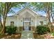 Community clubhouse featuring a white facade, stone accents, and gated entry amidst lush greenery at 12036 Duke Lancaster Dr, Charlotte, NC 28277
