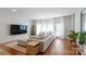 A bright living room featuring hardwood floors, large sectional, and sun-filled windows at 12036 Duke Lancaster Dr, Charlotte, NC 28277