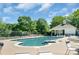 Community pool surrounded by lush landscaping, lounge chairs, and a charming pool house at 12036 Duke Lancaster Dr, Charlotte, NC 28277