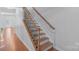 A staircase with wooden steps, iron railings, and trim is well lit with natural light at 12036 Duke Lancaster Dr, Charlotte, NC 28277