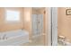 Bright bathroom showcasing a soaking tub, enclosed shower, tile floors, and a wooden vanity at 1219 Century Dr, Clover, SC 29710