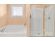 Bathroom showcasing a soaking tub, glass-enclosed shower, and a window with blinds for privacy at 1219 Century Dr, Clover, SC 29710