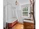 Charming bathroom featuring a clawfoot tub, vintage mirror, and a window view at 1233 General Hoke Dr, Lincolnton, NC 28092