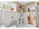 Vintage bathroom with pedestal sink, white tile walls, marble floor, and decorative wallpaper at 1233 General Hoke Dr, Lincolnton, NC 28092