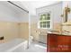 Bright bathroom featuring a tub, vanity with wood cabinets, and a window providing natural light at 1233 General Hoke Dr, Lincolnton, NC 28092