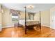 Spacious bedroom with hardwood floors, natural light, and classic four poster bed at 1233 General Hoke Dr, Lincolnton, NC 28092
