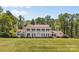A stately residence with a red roof and white exterior, complemented by a lush green lawn and mature trees at 1233 General Hoke Dr, Lincolnton, NC 28092
