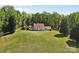 Wide shot of a stately home with a red roof, white exterior, and large lawn surrounded by mature trees at 1233 General Hoke Dr, Lincolnton, NC 28092