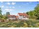 A full view of the exterior featuring a red roof and lush backyard with gardens at 1233 General Hoke Dr, Lincolnton, NC 28092