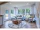 Sunlit living room with hardwood floors, comfortable seating, and large windows showcasing the backyard at 124 Fordham Ct # 19, Fort Mill, SC 29715