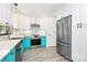 Bright kitchen features white cabinetry, stainless steel appliances, subway tile backsplash, and colorful turquoise lower cabinets at 1432 Deer Forest Dr, Fort Mill, SC 29707