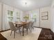 Inviting dining room with many windows with wooden shutters, hardwood floors and a modern light fixture at 1514 S Rensselaer Pl, Charlotte, NC 28203