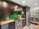Elegant kitchen with stainless steel appliances, dark wooden cabinets and vibrant green backsplash at 1514 S Rensselaer Pl, Charlotte, NC 28203
