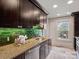 Stylish kitchen features granite counters, vibrant green tile backsplash and stainless steel appliances at 1514 S Rensselaer Pl, Charlotte, NC 28203