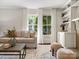 Cozy living room featuring large windows, hardwood floors, and fireplace with built-in shelves at 1514 S Rensselaer Pl, Charlotte, NC 28203