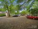 Gravel parking area surrounded by mature trees and landscaping adjacent to homes at 1514 S Rensselaer Pl, Charlotte, NC 28203