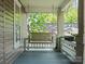 Inviting porch featuring a classic swing, white railing, and views of the lush, green surroundings at 1514 S Rensselaer Pl, Charlotte, NC 28203
