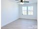 This bedroom has two windows, hardwood floors, a ceiling fan, and white walls with a white trim at 1525 Solitude Ct, Kannapolis, NC 28081