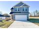 Two-story home with blue siding, white trim, a two-car garage and concrete driveway at 1525 Solitude Ct, Kannapolis, NC 28081