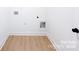 Bright laundry room with hardwood floors and white walls with a white trim around the room's base at 1525 Solitude Ct, Kannapolis, NC 28081