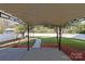 View of the backyard patio with a canopy, fire pit, and white picket fence in the background at 15814 Herring Gull Way, Charlotte, NC 28278
