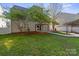 Backyard featuring a well-maintained lawn, canopy patio, and a white picket fence at 15814 Herring Gull Way, Charlotte, NC 28278